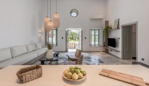 a living room with a couch and a table with a bowl of fruit at Sunset Mansion in Plaka Milou