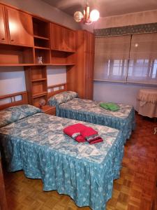 two beds in a room with wooden cabinets at Alojamiento bueu centro in Bueu