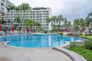 a swimming pool with a large building in the background at Ocean Front Condo Sleeps 4 Adults-Grand Venetian T3000-1606 in Puerto Vallarta