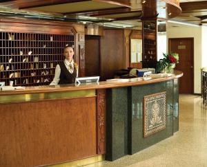 Eine Frau steht an einem Schalter in einer Bibliothek in der Unterkunft Premier Hotel Rus in Kiew