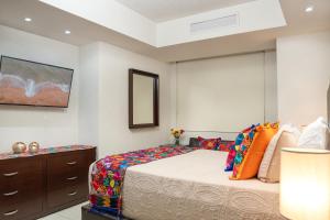 a bedroom with a bed and a dresser and a mirror at Ocean Front Condo Sleeps 4 Adults-Grand Venetian T3000-1606 in Puerto Vallarta +27 photos