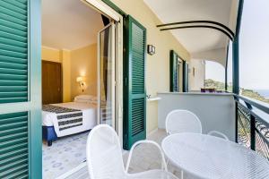 a room with a balcony with a bed and chairs at Best Western Hotel La Solara in Sorrento