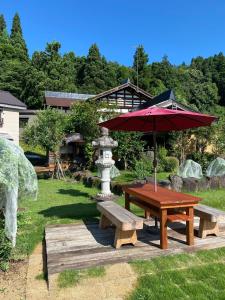 einen Picknicktisch mit einem Regenschirm und einem Brunnen in der Unterkunft Jonobien - Vacation STAY 13238 in Minami Uonuma