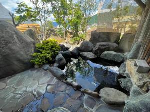 einen Garten mit einem Teich mit Felsen und Bäumen in der Unterkunft Jonobien - Vacation STAY 13238 in Minami Uonuma