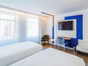 a hotel room with two beds and a desk at Novotel Rio de Janeiro Leme in Rio de Janeiro +120 photos