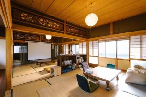 uma sala de estar com um sofá e um ecrã em SUSAMI LIFE HAUS - Vacation STAY 85652v em Esumi