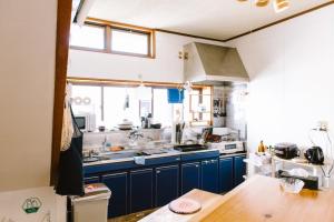 una cucina con armadi blu e piano di lavoro di SUSAMI LIFE HAUS - Vacation STAY 85652v a Esumi