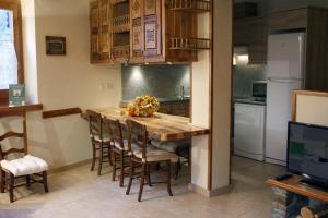 eine Küche mit einem Holztisch und einigen Stühlen in der Unterkunft Apartamentos Valle de Aran in Mont