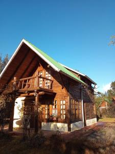 een groot houten huis met een gambrel dak bij Cabaña Ruca Kushe in Lago Puelo