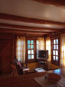 uma sala de estar com uma mesa e uma televisão em Cabaña Ruca Kushe em Lago Puelo