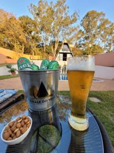 a glass of beer and peanuts on a table at CHALÉ DO VALE - EXCLUSIVIDADE E CONFORTO!! in Atibaia