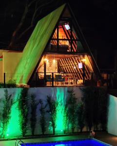 una casa iluminada por la noche con luces verdes en CHALÉ DO VALE - EXCLUSIVIDADE E CONFORTO!! en Atibaia
