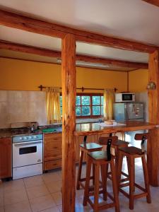 a kitchen with a table and some chairs in it at Cabaña Ruca Kushe in Lago Puelo