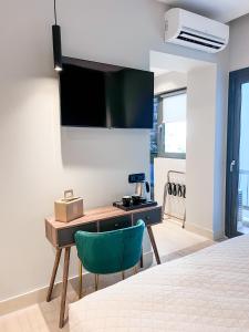 una camera da letto con una scrivania e una sedia verde di Royalty Suites Psyrri ad Atene Altre 91 foto