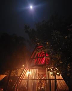 a house lit up at night with a full moon at CHALÉ DO VALE - EXCLUSIVIDADE E CONFORTO!! in Atibaia