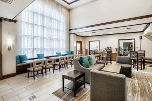 a waiting room with couches and tables and chairs at Staybridge Suites Gulf Shores by IHG in Gulf Shores