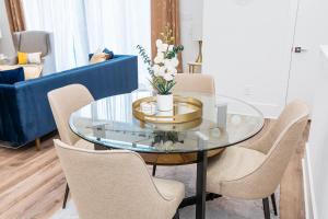 a glass table with chairs and a blue couch at Downtown Houston Modern Home in Houston