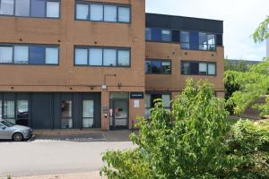 a brick building with a car parked in front at MK shortstay Deluxe- Capital Drive in Milton Keynes