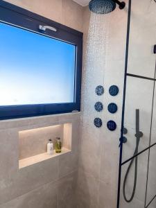 a bathroom with a shower with a window at Royalty Suites Psyrri in Athens