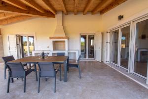 Un patio con una mesa y sillas de madera. en Villa Tereza Residence, en Labin