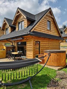a log home with a deck and a house at Chill and Rest Apartments in Falsztyn