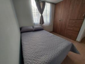 - une chambre avec un lit dans une pièce dotée d'une fenêtre dans l'établissement Apartamento Luna 170, à Bogotá