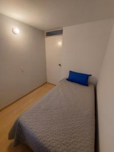a bedroom with a bed with a blue pillow on it at Apartamento Luna 170 in Bogotá