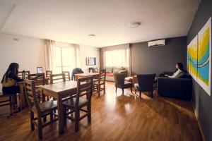 una sala de estar con personas sentadas en un sofá y una mesa en Chill Inn Hostel en Mendoza