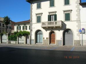 a white building with a balcony on a street at Lo Studio in Terranuova Bracciolini