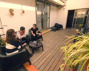 a group of people sitting on a deck at Chill Inn Hostel in Mendoza