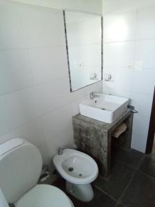 a bathroom with a white toilet and a sink at Luna Gris in La Pedrera +16 photos