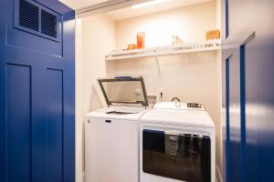 uma pequena cozinha com uma máquina de lavar roupa e uma porta azul em Oki Dokey by Oak Island Accommodations em Oak Island
