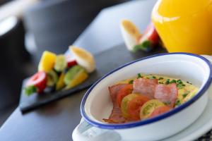 a bowl of food on a plate with fruit at Hotel Capital Bellet in Santiago