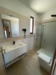 bagno con lavandino, servizi igienici e specchio di Crival club & more a Palagiano