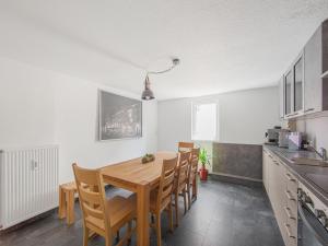 ヘルボルツハイムにあるModern Apartment in Herbolzheim with Extensive Kitchenのキッチン、ダイニングルーム(木製のテーブルと椅子付)