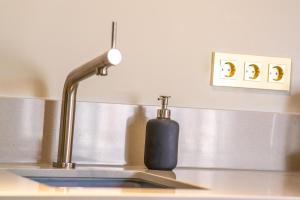 a kitchen sink with a soap dispenser next to aaucet at New Family Penthouse 7Min from Rotterdam Central Station top floor app4 in Schiedam