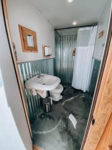 uma casa de banho inundada com um lavatório e um WC em Wander Camp Olympic em Port Angeles