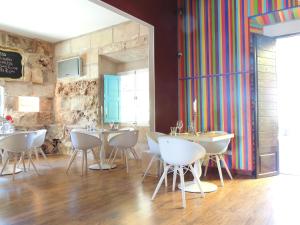 Habitación con mesas, sillas y una pared colorida. en loftOtel canet en Esporles