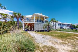a large house on the beach with palm trees at Sunny Side Up in Dauphin Island