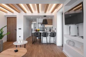 een keuken en een woonkamer met een tafel en stoelen bij Almy Luxury Apartments in Chania