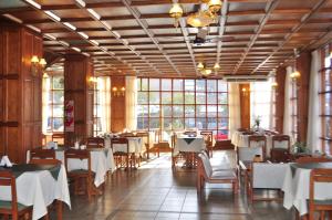 a dining room with tables and chairs and windows at Hotel Arona in Villa Carlos Paz
