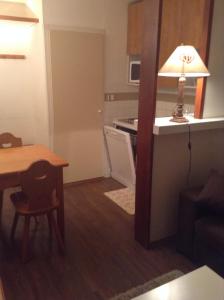 a small kitchen with a table and a lamp in a room at Résidence Les Mélèzes in L'Alpe-d'Huez