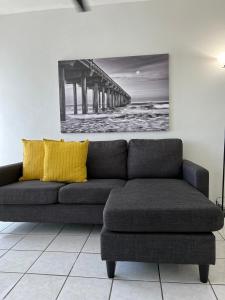 a couch with yellow pillows in a room with a pier at San Juan Apartments in San Juan