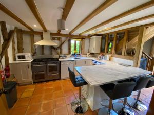 a kitchen with a table and some chairs in it at Brundish Suffolk Large 4-Bed Barn Stunning! in Woodbridge