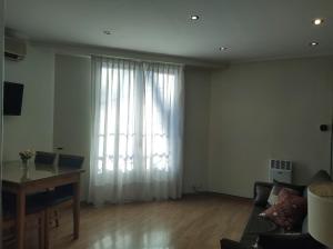 a living room with a couch and a large window at My Place Buenos Aires in Buenos Aires