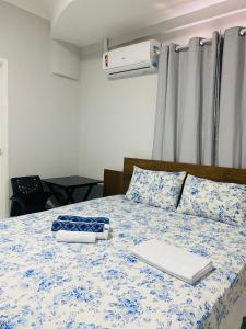 a bedroom with a bed with a blue and white comforter at Pousada Sertaneja in Canindé de São Francisco