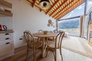 a dining room with a table and chairs and a window at Lodge Ojos de Nieve in Malalcahuello