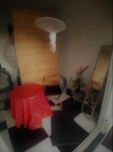 a living room with a red table and a lamp at Chambre avec cuisine et SDB semi-privatives separées dans un ecrin de verdure in Les Abymes