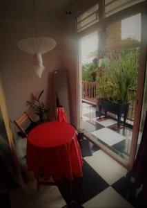 a room with a red table and a large window at Chambre avec cuisine et SDB semi-privatives separées dans un ecrin de verdure in Les Abymes