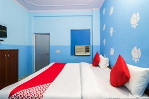 sypialnia z dużym łóżkiem z białymi i czerwonymi poduszkami w obiekcie OYO Hotel Moon Tara w mieście Faridabad